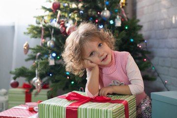 Obraz na płótnie Canvas Girl playing in the room with a Christmas tree