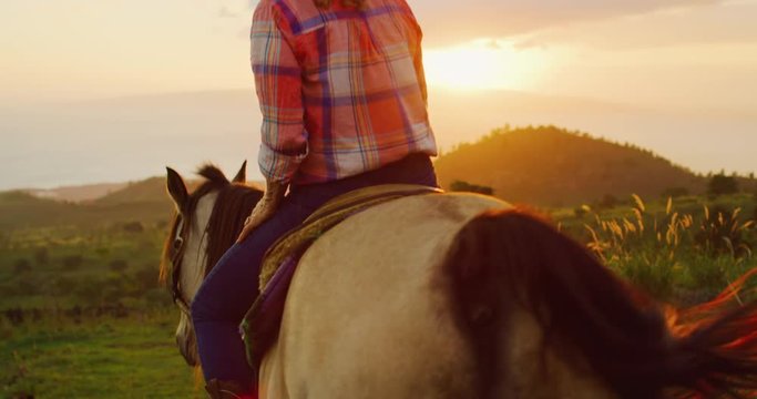 Woman horseback riding at sunset