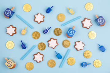 Blue background with multicolor dreidels, menora candles and chocolate coins. Hanukkah and judaic holiday concept. © Ekaterina_Molchanova