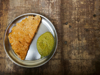 Oatmeal pancakes and green sauce in a plate on table