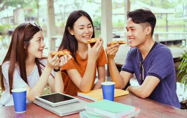 Students asian group together eating pizza in breaking time early next study class having fun and enjoy party italian food slice with cheese delicious at university outdoor