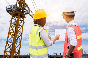 Concept Teamwork of building construction staff,Construction workers checking blueprints on site