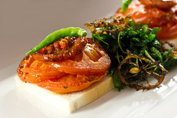Baked tomatoes and green pepper on white bread