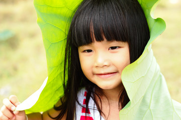 Little girl with a bright smile and lotus fields , asia girl.