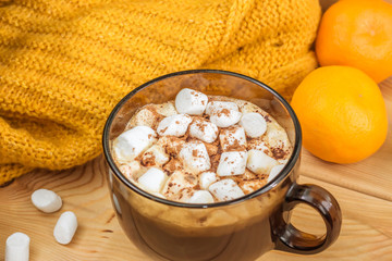 cup of coffee, cocoa with marshmallow, mandarins, plaid on wooden background. Christmas theme.