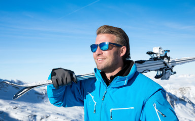 Young, sexy man is skiing in winter paradise in the alps with a beautiful blue sky and wonderful...