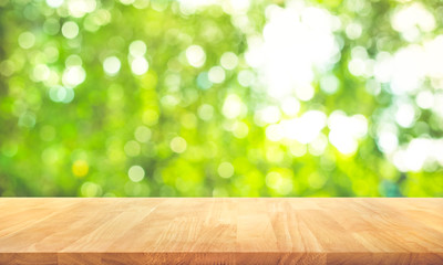 Wood table top on blur abstract green from garden in the morning background.For montage product...