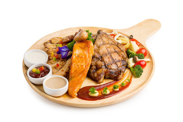 Closeup grilled beef and salmon fish steak with sauces served in wood plate isolated on white background