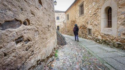 Fototapeta na wymiar Blurred tourist walking along small streets and large historical buildings, Caceres