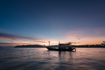 Fototapeta na wymiar Thai taxi boat at sunset in Andaman sea Thailand.
