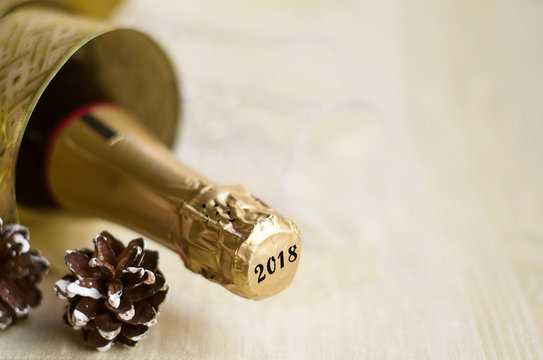 The bottle of champagne with gold glossy ribbon and natural cone. 2018 Happy New Year concept.Copy space