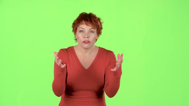 Red haired woman screams, she is aggressively attuned to her colleagues. Green screen