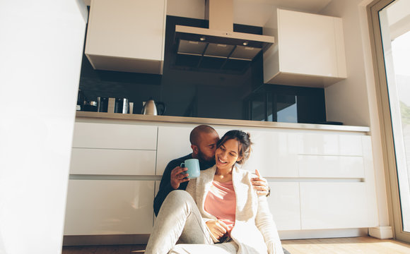Romantic young couple sitting on kitchen floor