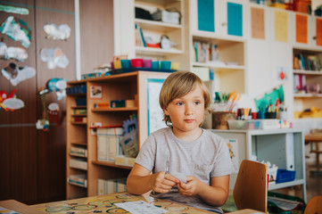 Cute little boy working in classroom, education, back to school concept