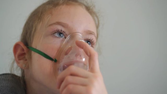 Little girl with mask for inhalation.