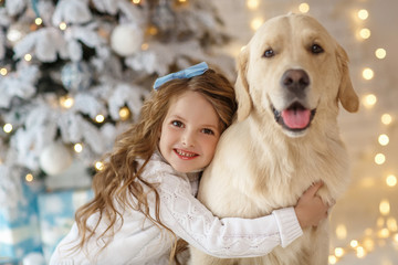 Little cute girl with a golden retriever dog 