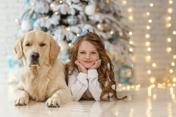 Little cute girl with a golden retriever dog 