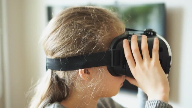 Little girl in VR headset at home.