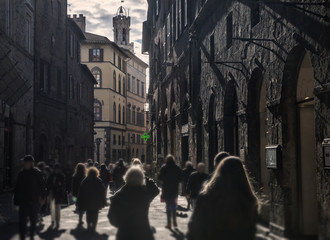 Naklejka na ściany i meble Blured crowd walking in bussy street in Siena, Italy, on dusk