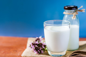 Obraz na płótnie Canvas A glass of milk and bottle of milk on wooden table with blue background,healthy drink,high calcium for kid elderly and pregnant women.
