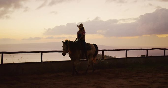 Woman horseback riding at sunset