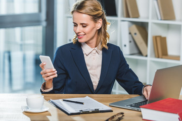 businesswoman with smartphone at workplace