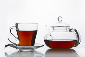 Tea cup with and tea leaf sacking on the wooden table and the tea plantations background