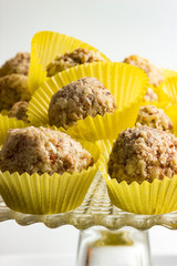 Vegane Mandeltrüffel ohne Backen zubereitet auf  Tortenplatte in Pralinenförmchen