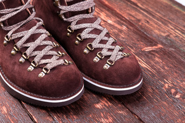 Brown man suede  boots on wooden background. Autumn or winter shoes.