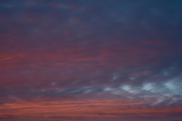 Dramatic colorful sunset sky with clouds. Blue background.