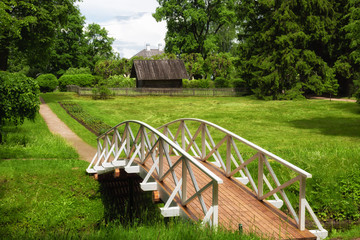 White wooden bridge in the old park in the village of Mikhailovskoye, Pskov region, Russia - obrazy, fototapety, plakaty