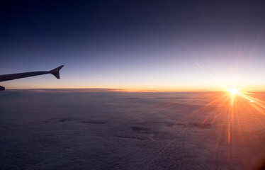 The airplane wing on amazing sunset background