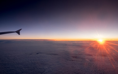 The airplane wing on amazing sunset background