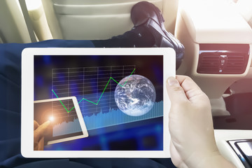 Hand hold tablet using internet to get big data from connecting to world wide web everywhere in the car.Image of earth furnished by NASA.