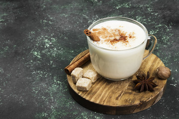 Christmas drink eggnog and ingredients on a green background. Copy space