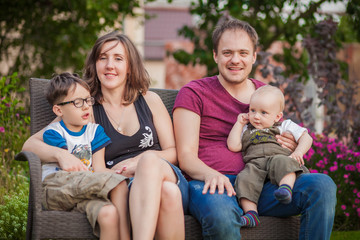 Young family with two kids sitting on bench