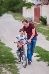 Fototapeta premium father teaching his son to ride a bike