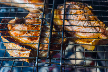 Pork steaks are fried in a street grill, close-ups