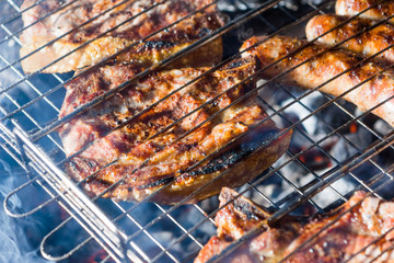 Pork steaks are fried in a street grill, close-ups