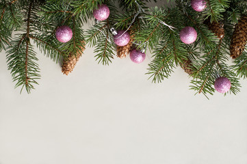 Fototapeta na wymiar Festive fir branches decorated with fir cones and pink shiny new year balls. Christmas background.