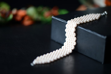 Beige beaded bracelet on a darck background close up