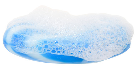 Bar of blue soap in the foam close up isolated