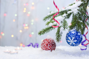 Christmas balls on a snow-covered fir branch