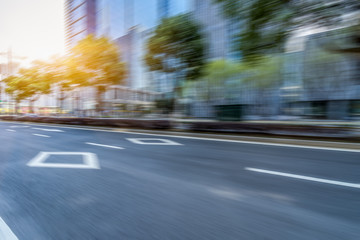 blurred empty urban road and modern buildings at a sunny day