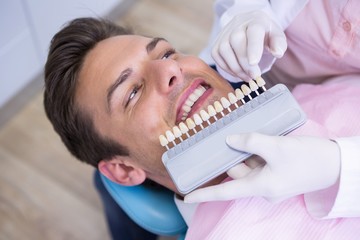 High angle view of dentist holding equipment while examining