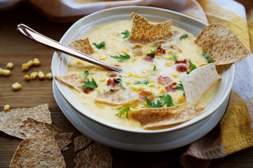 Corn chowder soup with bacon. Brown wooden background. Close-up view