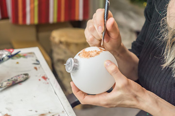 Painting of Christmas decorations, Woman paints with a brush Christmas ball