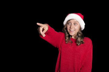 Excited Little girl in red sweater and Santa's cap is pulling the right hand and pointing with a finger.