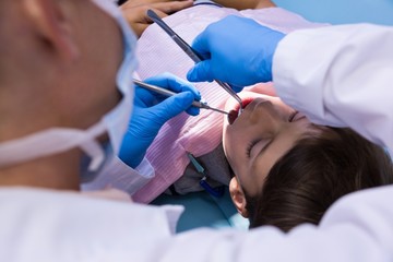 Obraz na płótnie Canvas Doctor giving treatment to boy at dental clinic
