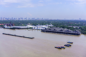 Tugboats towing sand barges along Chao Phraya river , Bangkok , Thailand